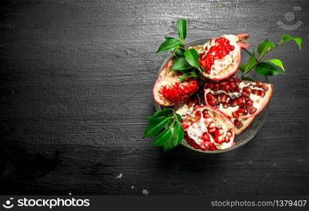 Fresh pieces of pomegranate in a bowl. On the black chalkboard.. Fresh pieces of pomegranate in a bowl.
