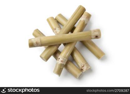 Fresh pieces of sugar cane sticks on white background