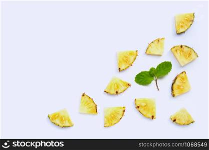 Fresh pineapple slices with mint leaves on white background. Copy space