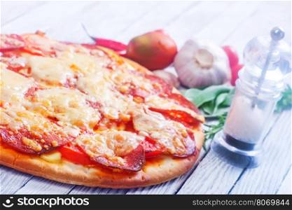 fresh pizza with salami and cheese on a table