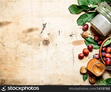 Fresh plum pulp in a glass jar. On wooden background.. Fresh plum pulp in a glass jar.