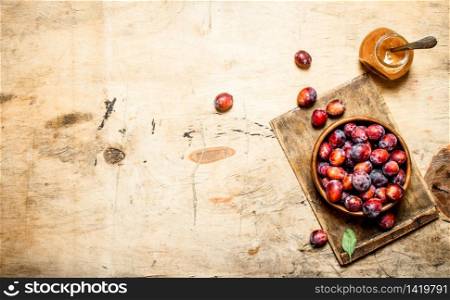 Fresh plum pulp in a glass jar. On wooden background.. Fresh plum pulp in a glass jar.