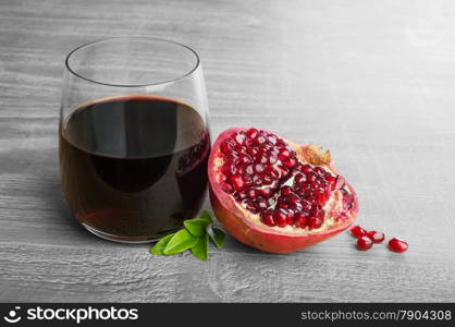 Fresh pomegranate fruit and pomegranate juice over wooden vintage table