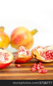 fresh pomegranate fruit on wood over white background