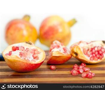 fresh pomegranate fruit on wood over white background
