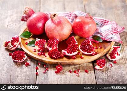 fresh pomegranates on wooden plate