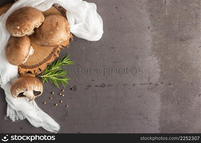 Fresh portobelloμshroom with a sprigs of rosemary in kitchen coutertop, rustic sty≤, close up.