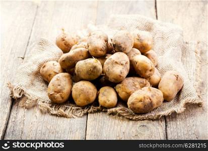 fresh potatoes on wooden table