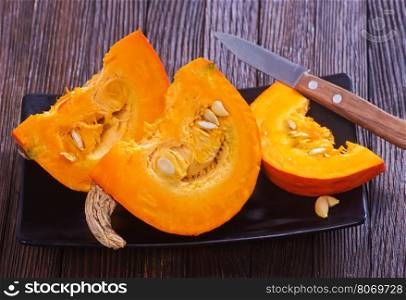 fresh pumpkin on wooden board and on a table