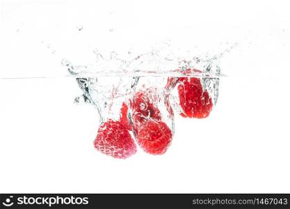 Fresh raspberries falling in water isolated on white background . Healthy food concept. Fresh raspberries falling in water on white background