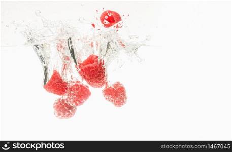 Fresh raspberries falling in water on white background . Healthy food concept. Fresh raspberries falling in water on white background
