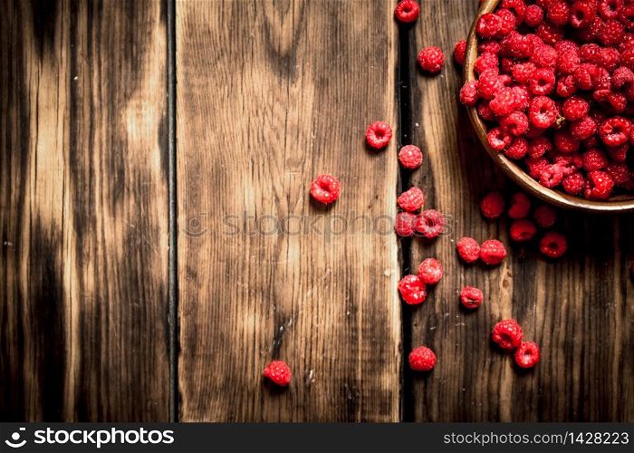 Fresh raspberries in a bowl. On a wooden table.. Fresh raspberries in a bowl.