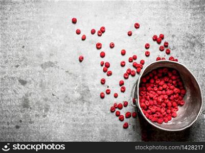 Fresh raspberries in the old pot. On a stone background.. Fresh raspberries in the old pot.