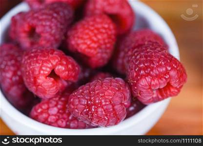 Fresh raspberry on bowl / Close up red raspberries fruit on wood background , top view