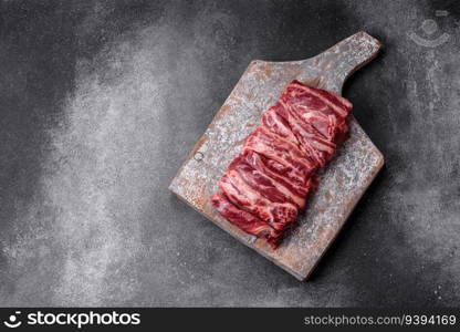 Fresh raw beef ribs with salt, spices and herbs prepared for grilling