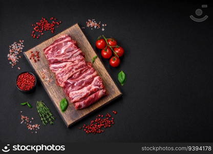 Fresh raw beef ribs with salt, spices and herbs prepared for grilling