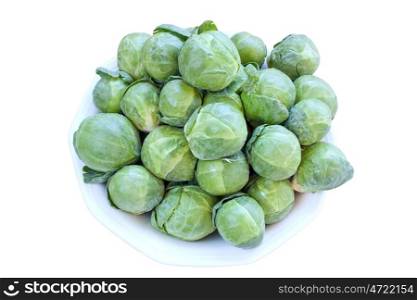Fresh raw brussels cabbage on a plate over white background