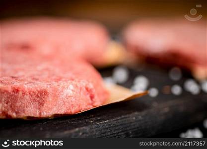 Fresh raw burger on the table. Macro background. High quality photo. Fresh raw burger on the table.