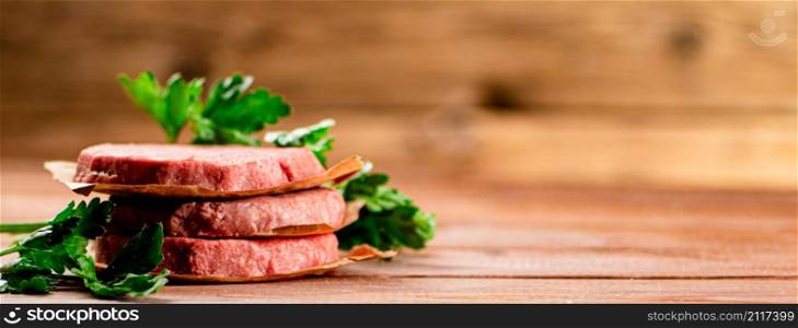 Fresh raw burger on the table. On a wooden background. High quality photo. Fresh raw burger on the table.