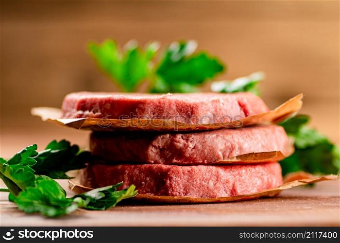 Fresh raw burger on the table. On a wooden background. High quality photo. Fresh raw burger on the table.