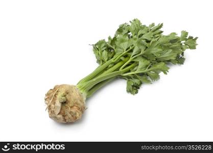 Fresh raw Celery root with green leaves on white background