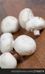 Fresh raw champignon mushrooms on wooden background