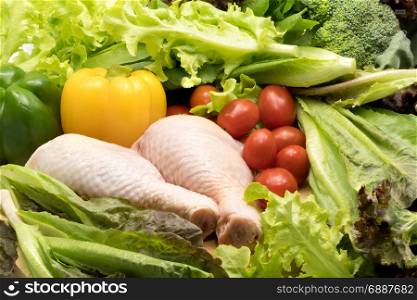 Fresh raw chicken and different kinds of vegetables on z wooden table