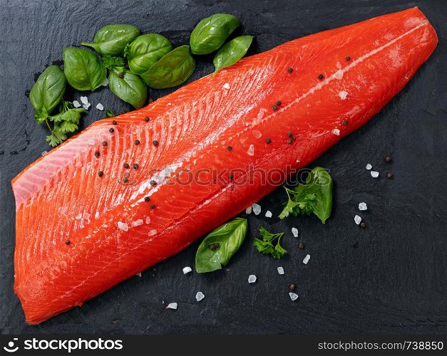 Fresh raw copper river sockeye salmon fillet on natural stone with herbs and seasoning