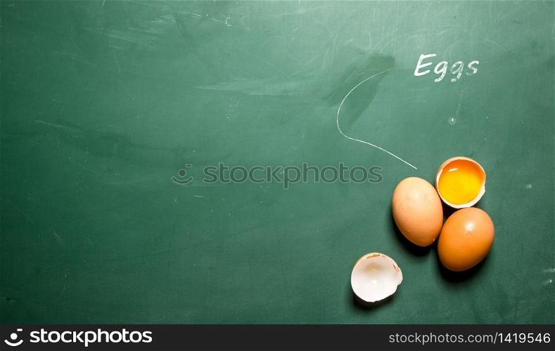 Fresh raw eggs . On a green chalkboard. Fresh eggs .