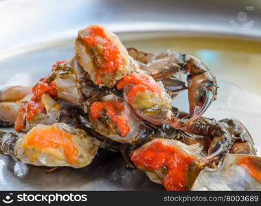 Fresh raw female crab marinated in fish sauce on stainless steel serving tray. Thai street food.