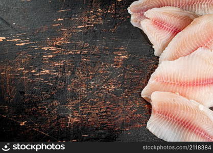 Fresh raw fish fillet on the table. Against a dark background. High quality photo. Fresh raw fish fillet on the table.