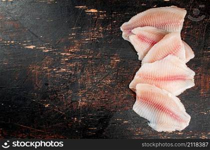 Fresh raw fish fillet on the table. Against a dark background. High quality photo. Fresh raw fish fillet on the table.