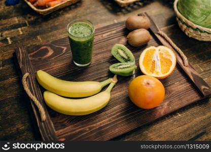 Fresh raw fruits on wooden tray closeup, nobody, top view. Healthy food concept. Organic nutrition. Fruits on wooden tray closeup, nobody, top view