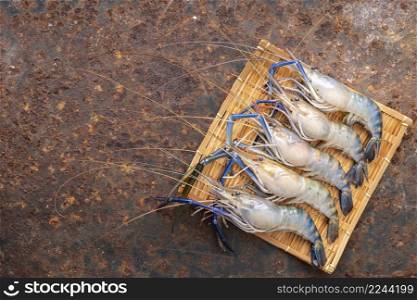 fresh raw giant freshwater prawns on rusty texture background with copy space for text, top view, river prawn