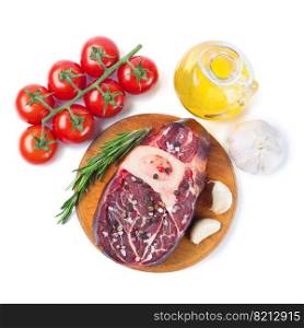 Fresh raw meat beef steak with bone with spices, rosemary, tomatoes, garlic and olive oil on wooden cutting board isolated on white background. Top view. Flat lay.. Meat steak and cooking ingredients isolated on whtie background.