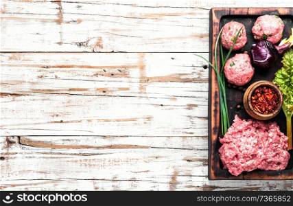 Fresh raw minced beef on cutting board and ingredients. Raw chopped meat