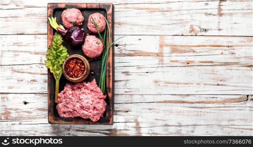 Fresh raw minced beef on cutting board and ingredients. Raw minced meat