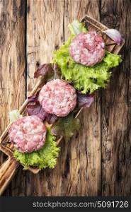 fresh raw minced meat beef. raw minced meat and lettuce on rustic wooden background