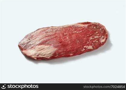 Fresh raw natural beef flank sreak for cooking isolated on white background with shadows, place for text. The whole organic raw veal pound of flesh for bbq on a white background with shadows.
