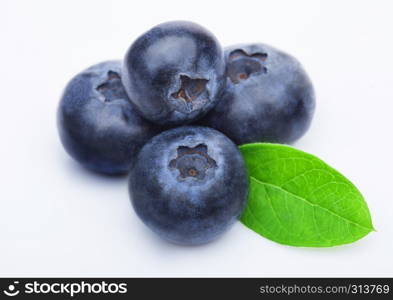 Fresh raw organic blueberries with leaf on white background.