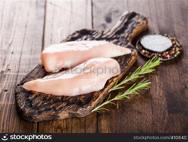 Fresh Raw Organic Chicken Fillet Breast on vintage wooden board with spices and herbs on wood