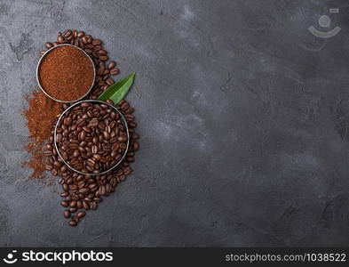 Fresh raw organic coffee beans with ground powder and coffee trea leaf on black. Space for text