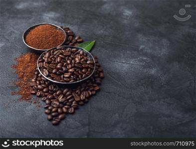 Fresh raw organic coffee beans with ground powder and coffee trea leaf on black. Space for text