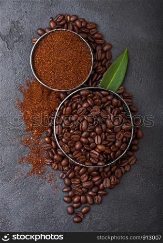 Fresh raw organic coffee beans with ground powder and coffee trea leaf on black