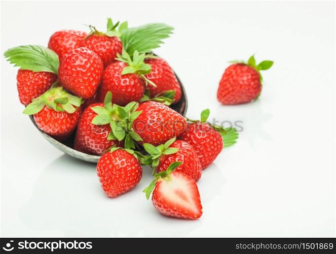 Fresh raw organic strawberries in steel bowl plate on white background with berries next to it. Top view
