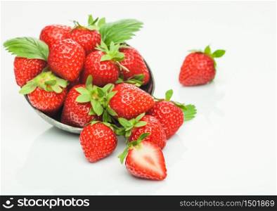 Fresh raw organic strawberries in steel bowl plate on white background with berries next to it. Top view
