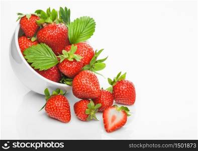 Fresh raw organic strawberries in white ceramic bowl plate on white background with berries next to it. Top view