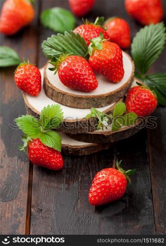 Fresh raw organic strawberries with leaf on timber plate on wooden background. Best summer berries with a lot of vitamins.
