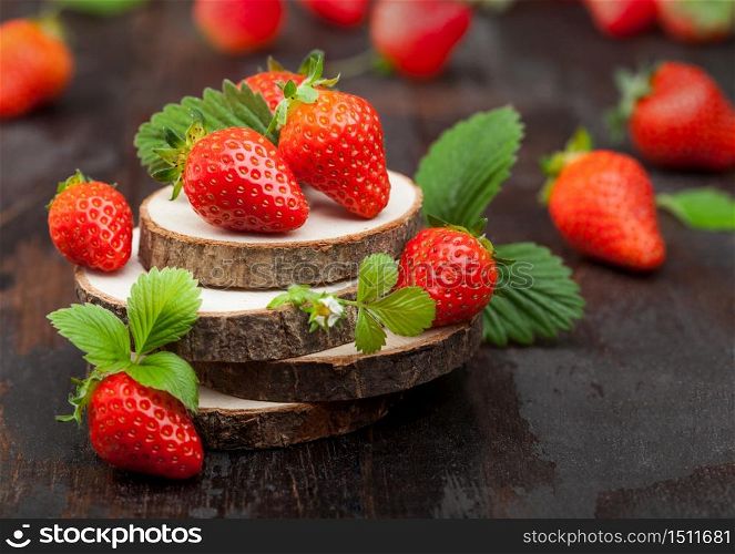 Fresh raw organic strawberries with leaf on timber plate on wooden background. Best summer berries.