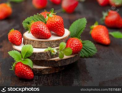 Fresh raw organic strawberries with leaf on timber plate on wooden background. Best summer berries.